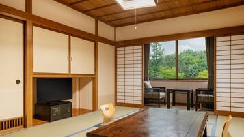 A traditional Japanese room with tatami flooring, a low table, and sliding doors.