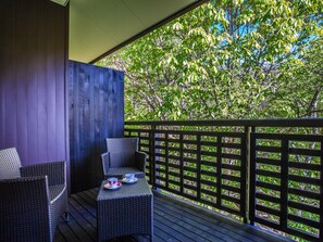 A covered outdoor seating area with wicker furniture and a table set with cups. - Wan Wan Paradise Takayama (Takayama)