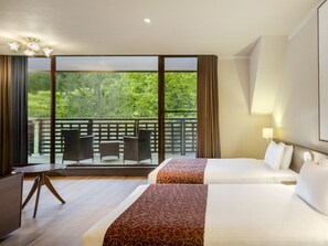 A hotel room with two beds, a balcony with outdoor furniture, and a view of greenery. - Wan Wan Paradise Takayama (Takayama)