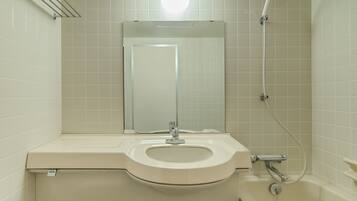 A bathroom with a toilet, sink, mirror, and shower.