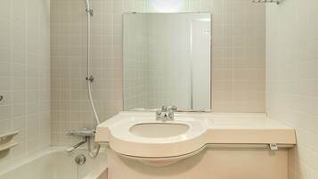 A bathroom with a bathtub, a sink, a mirror, and a towel rack.