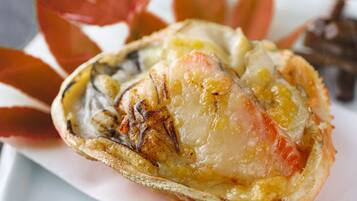 Primer plano de un plato de mariscos con salsa cremosa, posiblemente una cola de langosta, sobre un plato blanco.