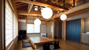 Ein traditioneller japanischer Raum mit Tatami-Bodenbelag, einem niedrigen Holztisch und Schiebetüren.