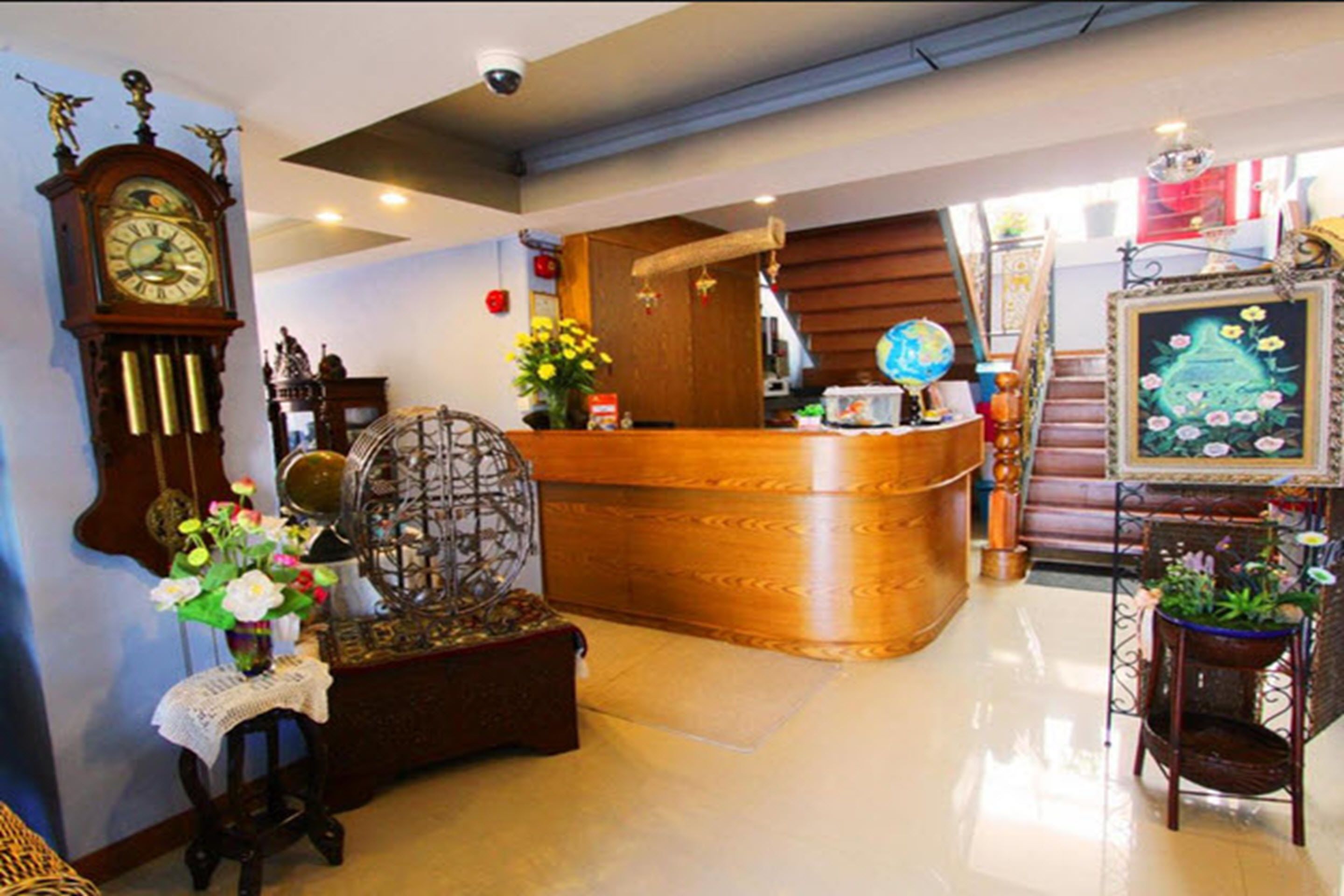 A reception area with a wooden counter, a vintage clock, and a globe.