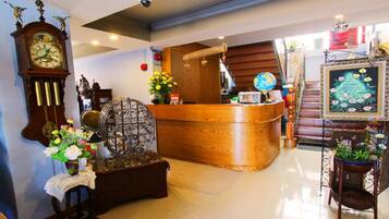 A reception area with a wooden counter, a vintage clock, and a globe.