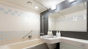 Un baño con bañera, lavamanos, espejo e inodoro.
