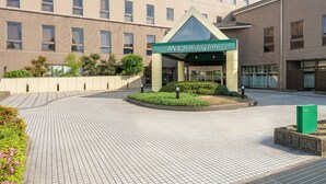 A hotel entrance with a green sign reading 'ANA Holiday Inn.' - ANA Holiday Inn Tosu by IHG   (Tosu)
