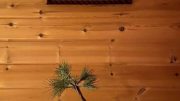 A wooden wall with a framed picture and a bonsai tree on a table.