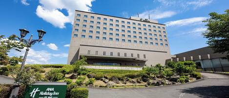 Un edificio moderno con un letrero que indica ANA Holiday Inn by IHG en Iwataki Kitakami.