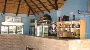 Eine Bar mit einer Ziegel-Theke, einer Kühlzelle und einem mit Flaschen befüllten Regal.