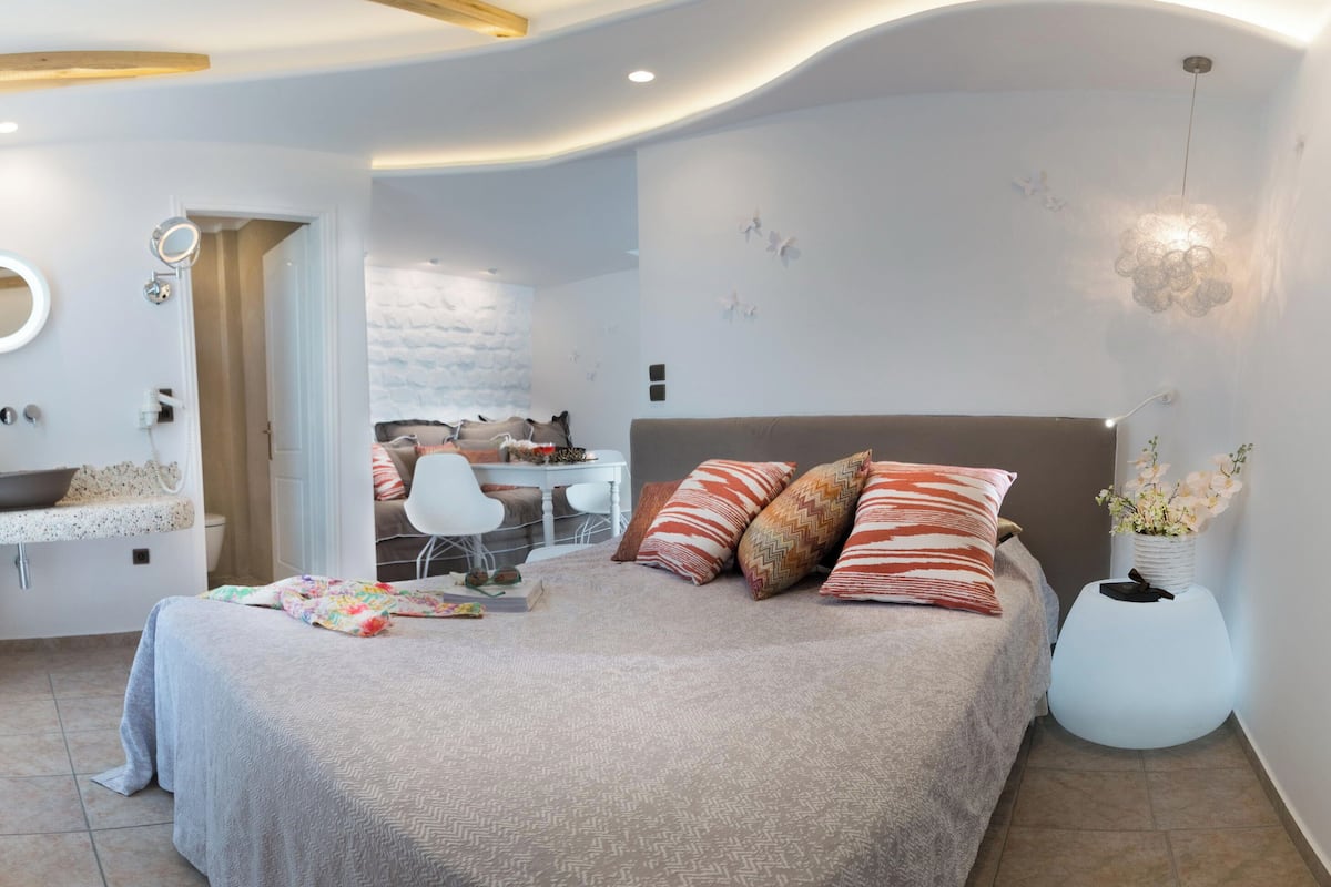 Une chambre moderne avec un grand lit, un bureau et une salle de bain.