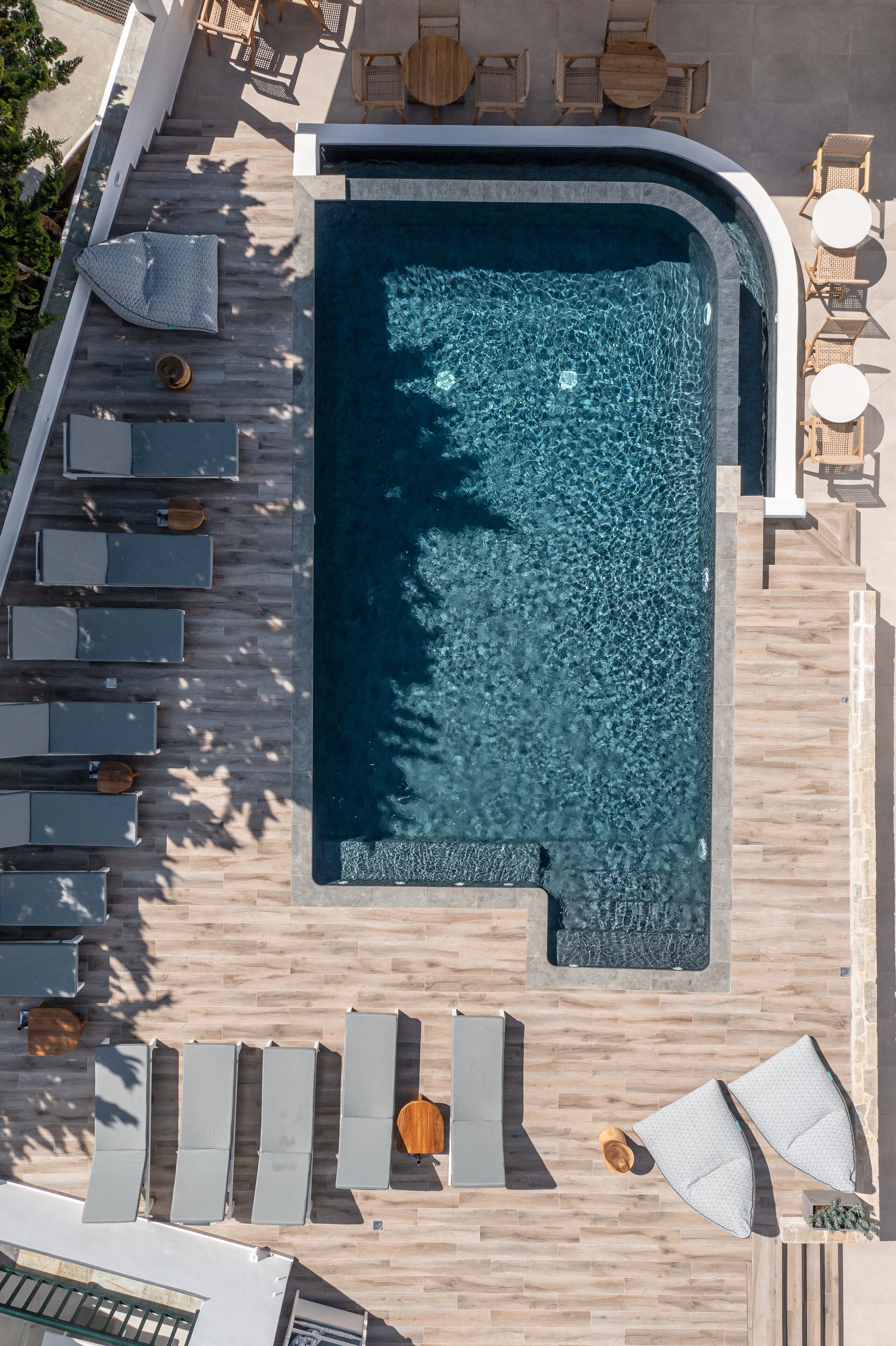 An aerial view of a swimming pool area with lounge chairs and a deck.