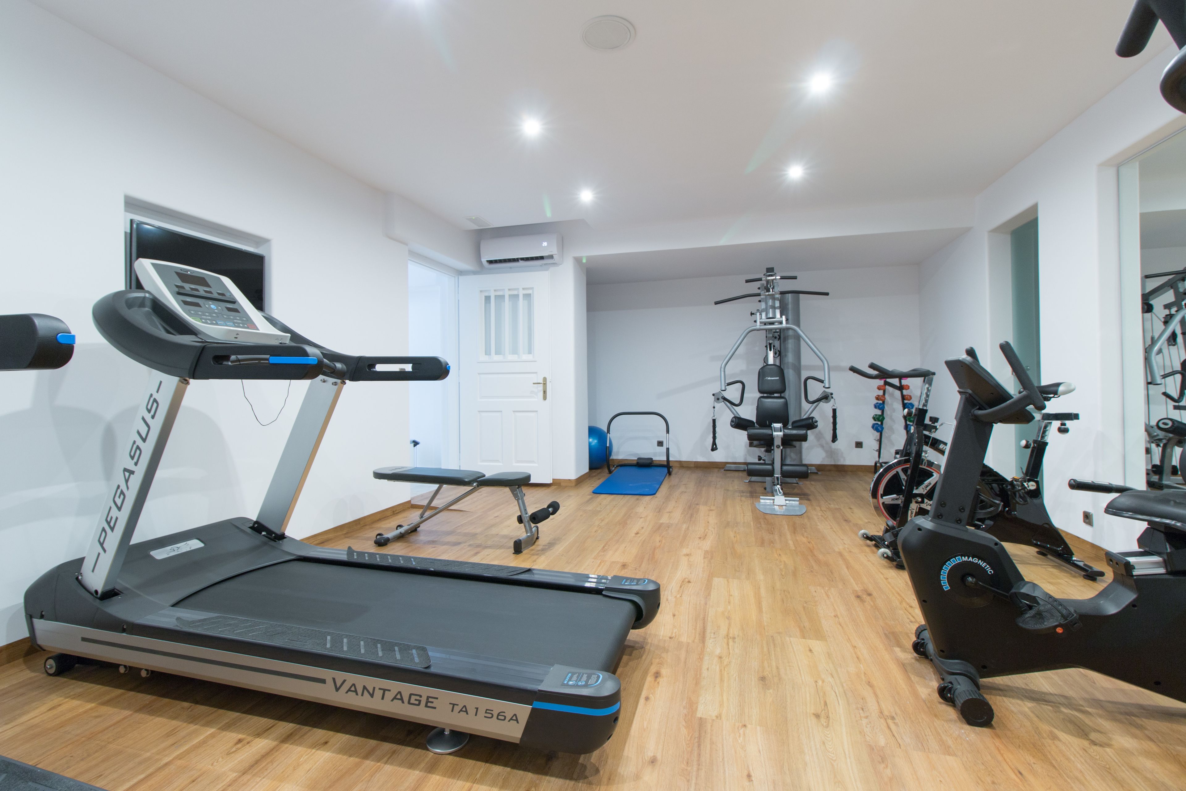 A gym with treadmills, stationary bikes, and exercise equipment.