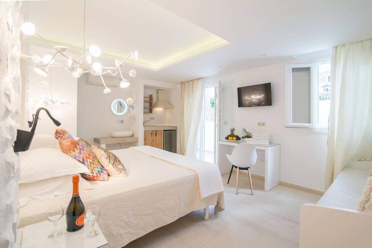 Une chambre d’hôtel moderne équipée d’un lit, d’un bureau, d’une télévision et d’un mini-bar.