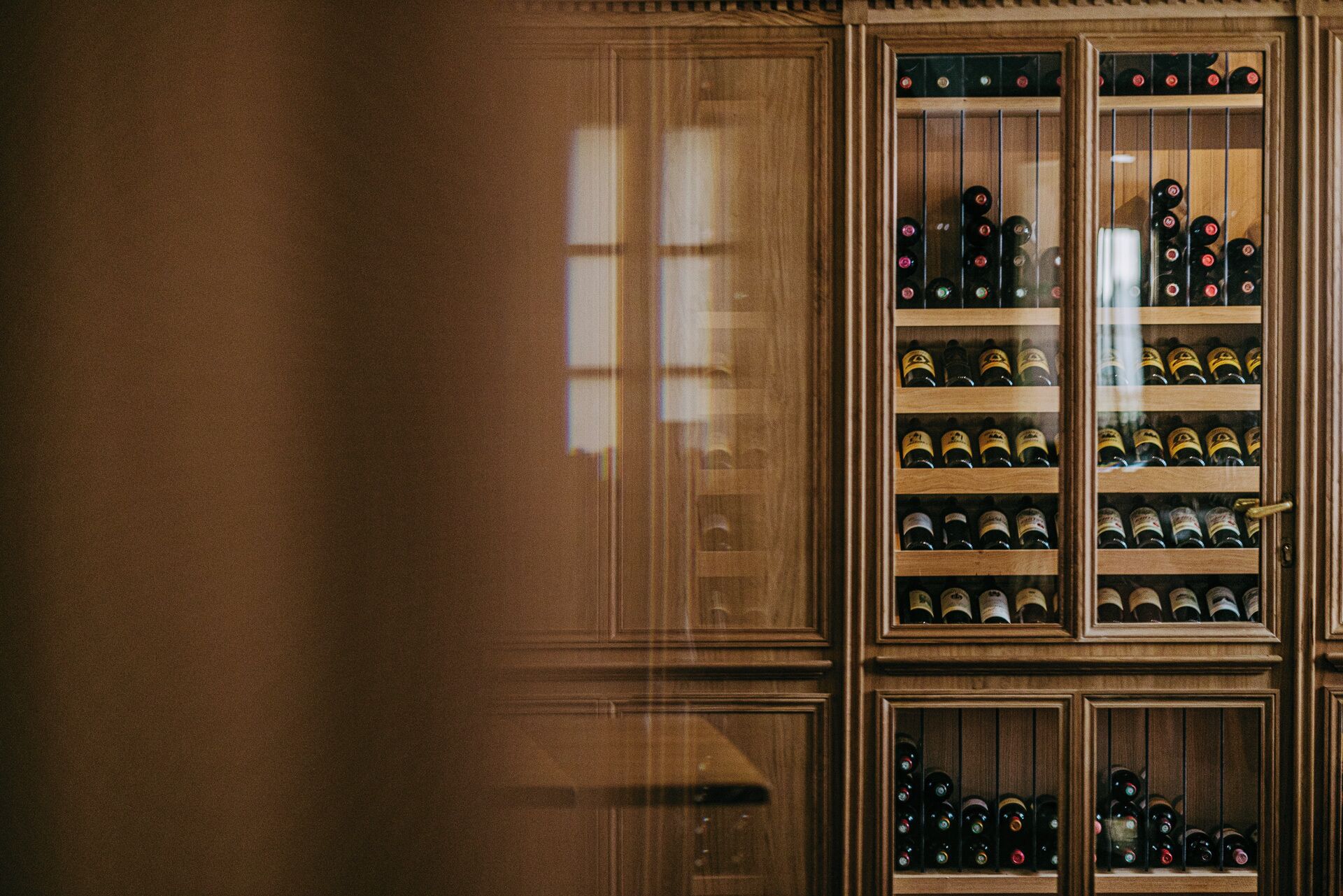 Una botellera de madera con varios estantes que contienen botellas.