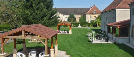 A courtyard with a gazebo, outdoor seating, and a well-maintained lawn.