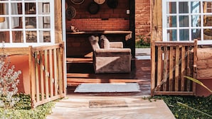 Una casa de madera rústica con un camino de piedra que lleva a un banco de madera y una chimenea de ladrillo.