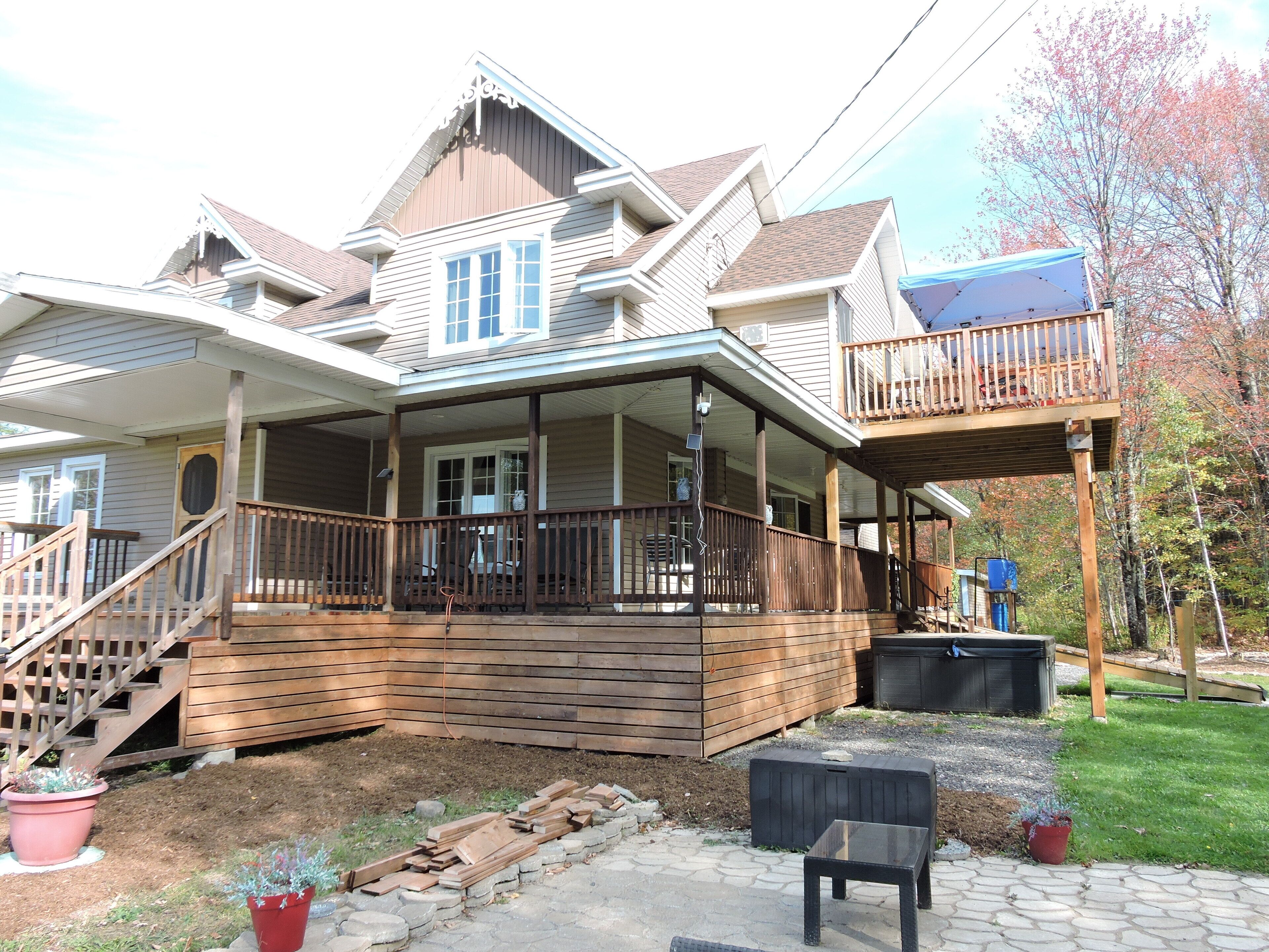 A two-story house with a covered porch and a balcony.