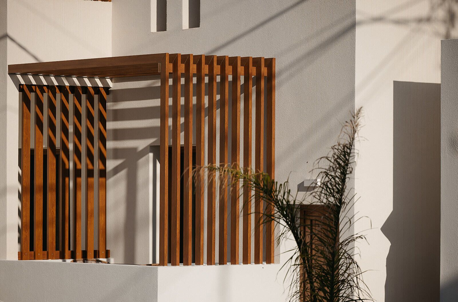 Een moderne gevel met verticale houten latten en een geometrisch raamontwerp.