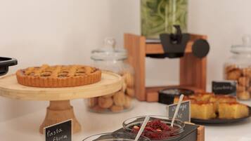 A buffet with various food items including a pie, jars of preserves, and a coffee station.