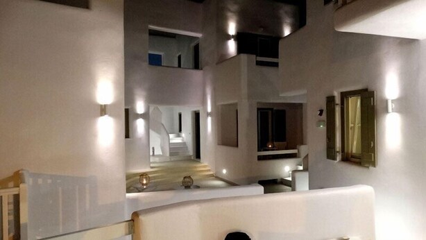 Un intérieur moderne avec un escalier menant à un deuxième étage, un éclairage encastré et un design minimaliste.
