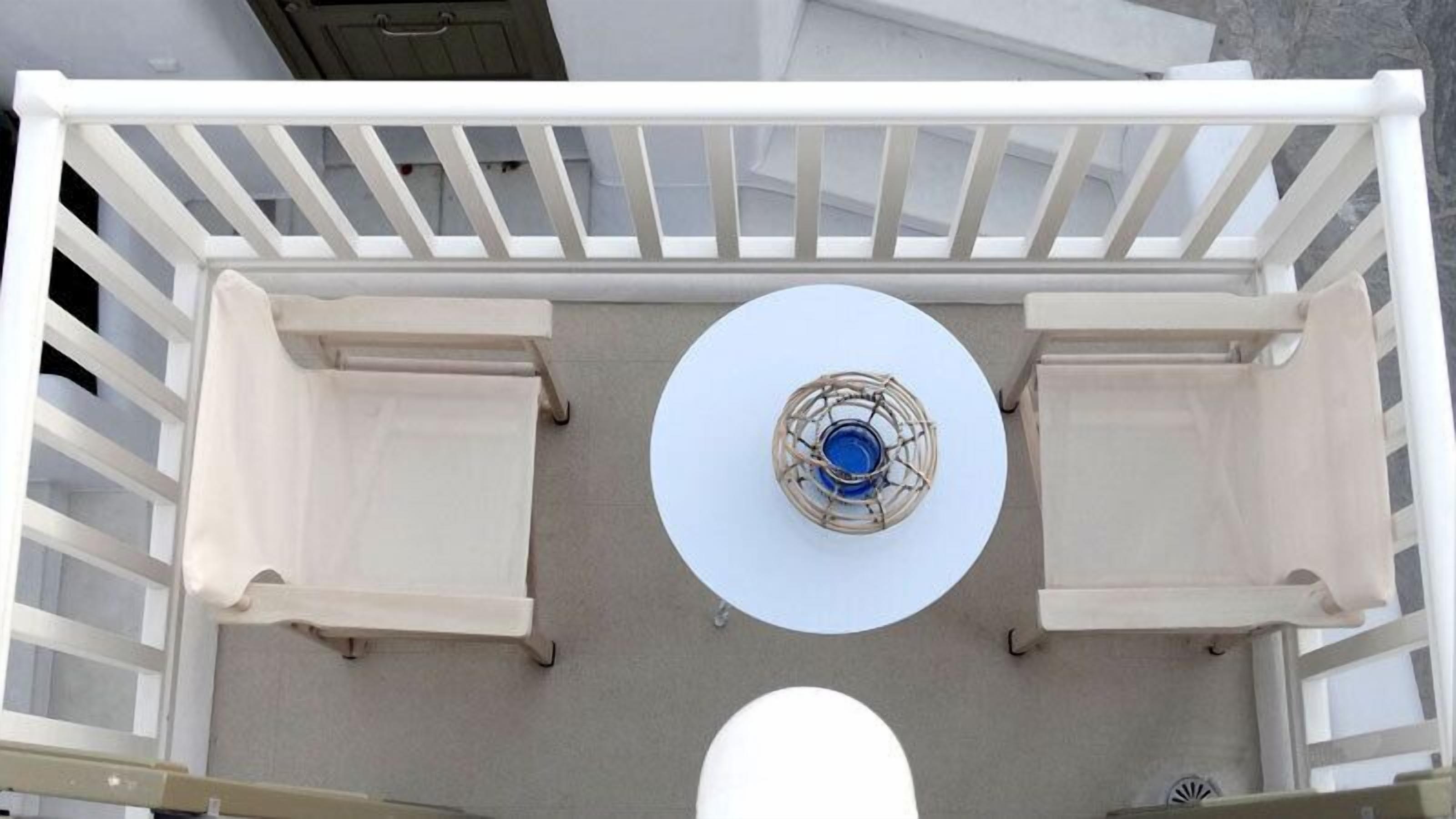 A circular seating area with a central table and two side tables, surrounded by a white railing.