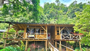Een houten chalet met een houten terras en een trap naar de ingang.