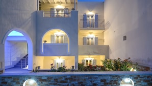 A multi-story building with a central staircase, balconies, and arched doorways. - Ormos Holiday Studios (Naxos)
