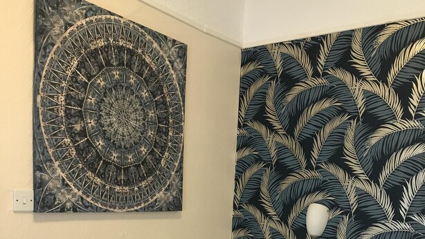 A hotel room with a bed, a wall tapestry, and a headboard with a leaf pattern. - The Feathers Hotel (Blackpool)