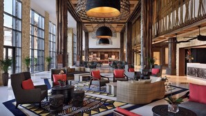 A spacious lobby with modern furniture, large windows, and decorative lighting fixtures. - Lapita, Dubai Parks and Resorts, Autograph Collection (Dubai)