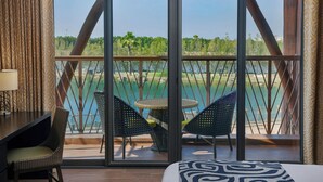 A hotel room with a balcony, a dining table, and two chairs. - Lapita, Dubai Parks and Resorts, Autograph Collection (Dubai)