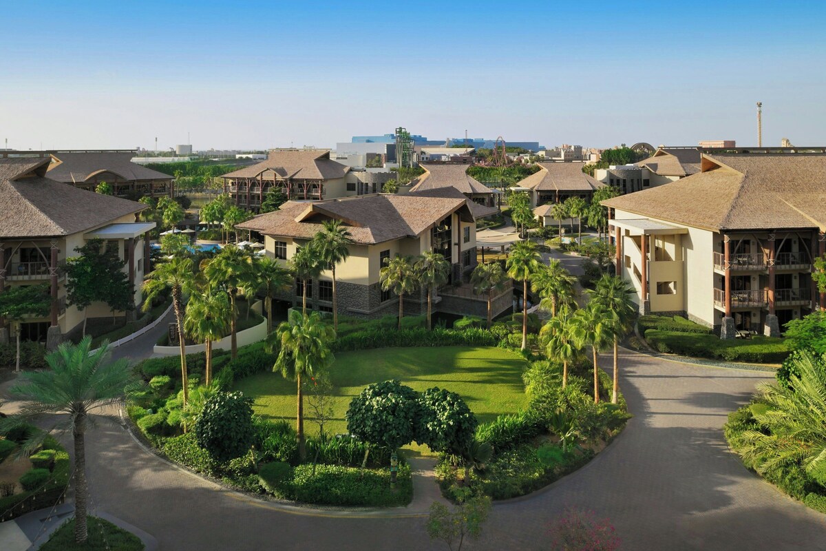 A resort with multiple buildings, a central courtyard, and palm trees.