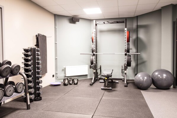A gym with weightlifting equipment, dumbbells, kettlebells, and exercise balls. - Comfort Hotel Kista (Kista)