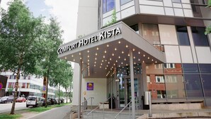 Exterior del Comfort Hotel Kista, con un diseño moderno, una entrada cubierta y el cartel de la oficina visible.