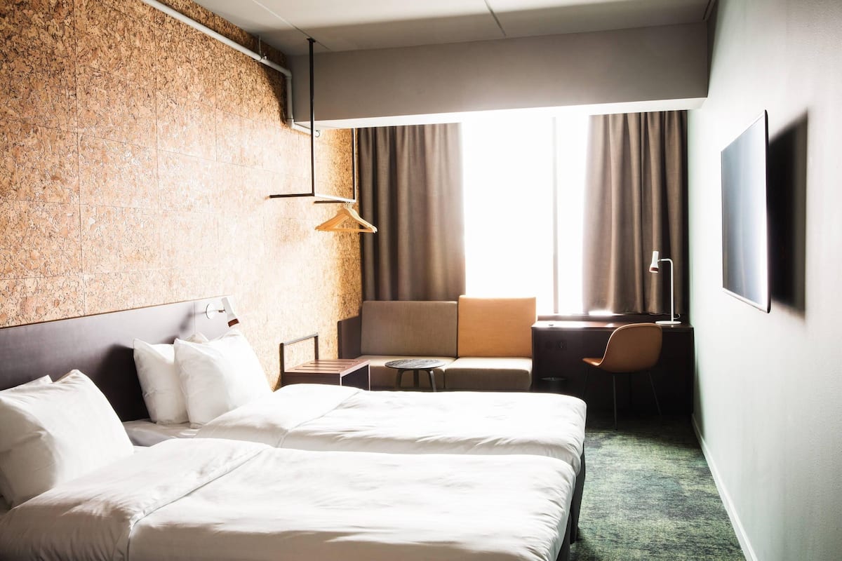 Une chambre d’hôtel avec un grand lit, un bureau, une chaise et un canapé.
