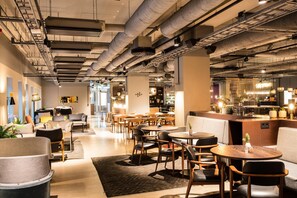 A modern interior with a bar area, seating arrangements, and exposed ductwork. - Comfort Hotel Kista (Kista)
