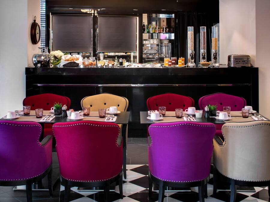A dining area with a bar, red and beige chairs, and a checkered floor.