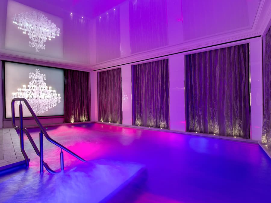 Una piscina techada, sillones reclinables de piscina