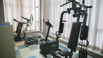 Un gimnasio con cintas de correr, elípticas y máquinas de pesas.