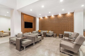 Relax and unwind in this stylish living area, featuring a large flat-screen TV, comfortable seating, and a convenient dining table.