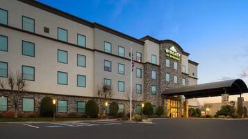 A hotel with a stone facade, multiple windows, and a covered entrance.