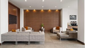 A modern lounge area with a sectional sofa, a small coffee table, and a potted plant.