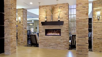 A modern interior with a stone fireplace, seating area, and decorative vases.