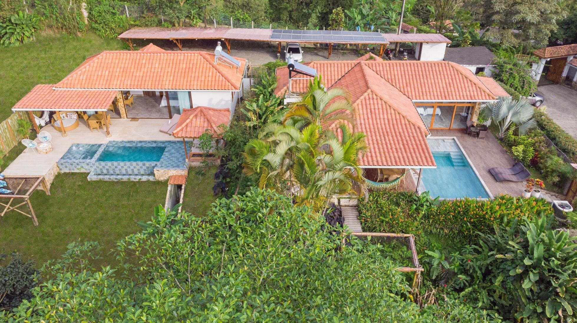 Una casa grande con piscina, paneles solares y un jardín bien cuidado.