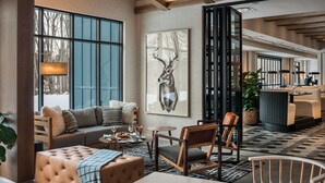 Un moderno vestíbulo de hotel con sofá, comedor y obras de arte.