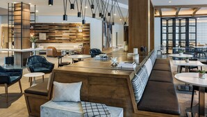 Un salón moderno con una zona de estar central, un bar y un comedor.