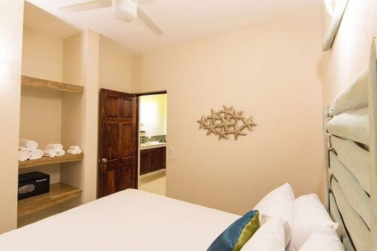 Ein Hotelzimmer mit Bett, Holztür, Wanddekoration und Ablage mit Handtüchern.