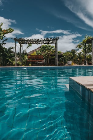 Una piscina al aire libre, sillones reclinables de piscina