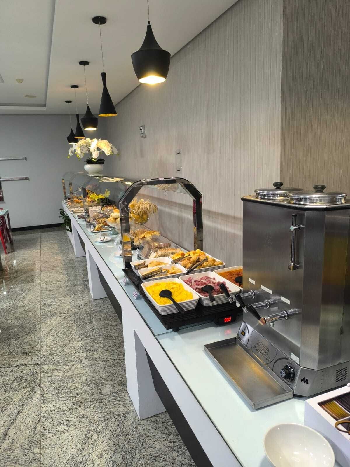 Un buffet proposant une variété de plats, une machine à café et un distributeur d’eau.