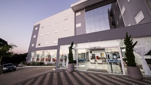 A modern hotel with a two-story structure, large glass windows, and a paved entrance area.